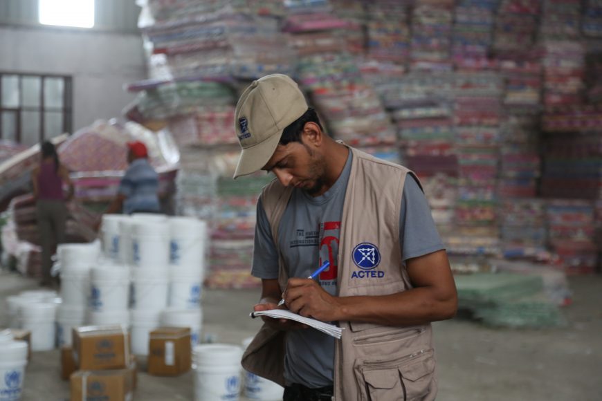 ACTED field staff checks supplies of distribution materials.